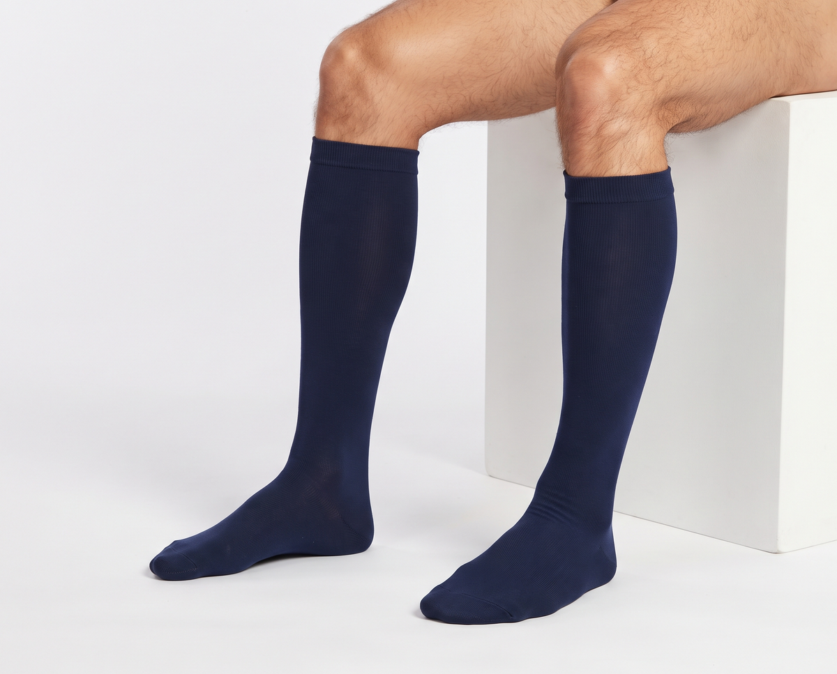 Calcetines de compresión de bambú KIMA para hombre en azul marino, hombre sentado